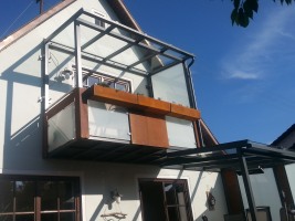 Abgehängter Stahlbalkon mit Terrassenüberdachung verzinkt und lackiert, Balkonfüllung VSG TVG Glas und Cortenstahl