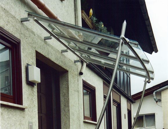 Eingangsüberdachung aus Edelstahl mit geschwungenen Stützen