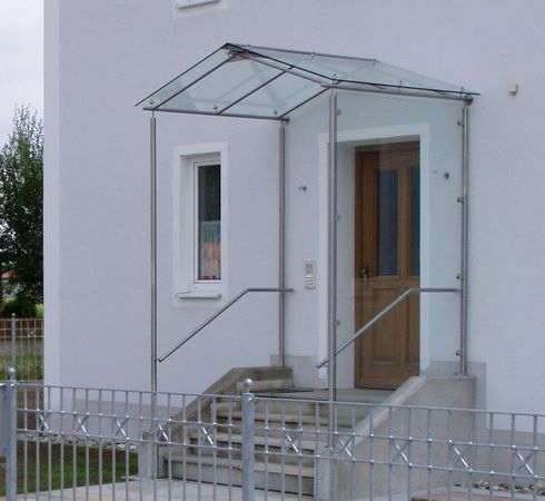 Eingangsüberdachung mit seitlichem Windschutz aus Glas