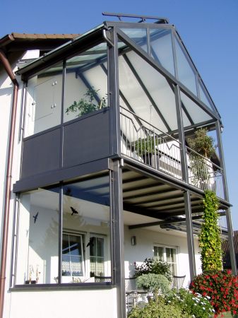 Balkonanbau mit verglaster Überdachung, seitlichem Windschutz,                              Sonnenrollo, Geländer mit Edelstahlhandlauf